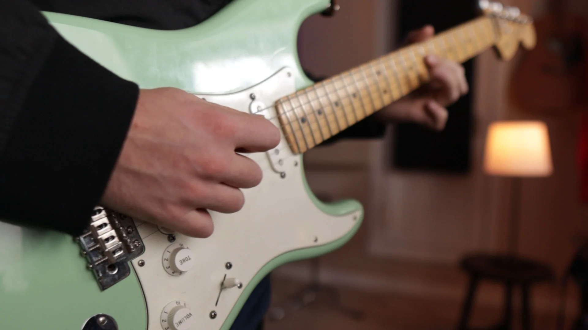 Guitarist's hand playing electric guitar, reflecting a hands-on musician's perspective on Logic Pro 11's new AI features