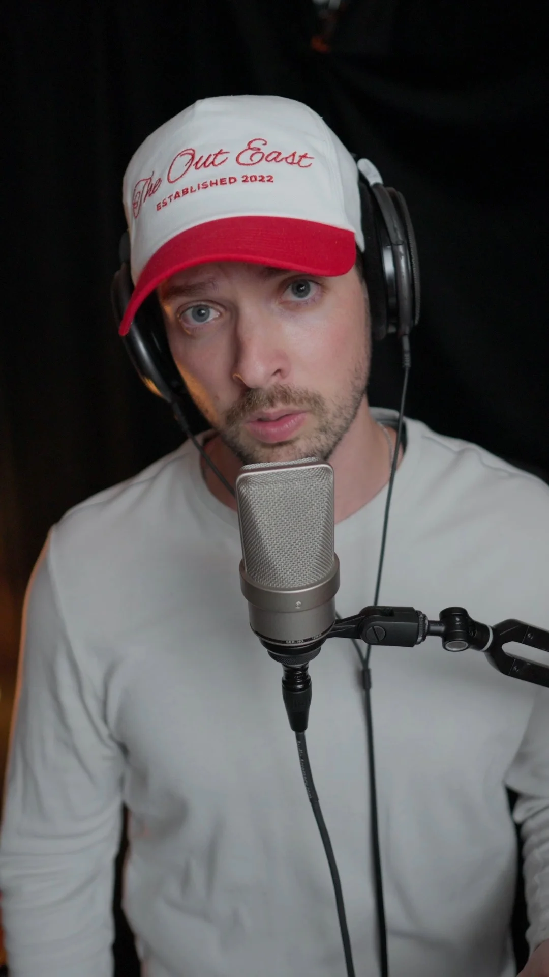 Mattie wearing headphones recording vocals with a detailed, clear condenser microphone