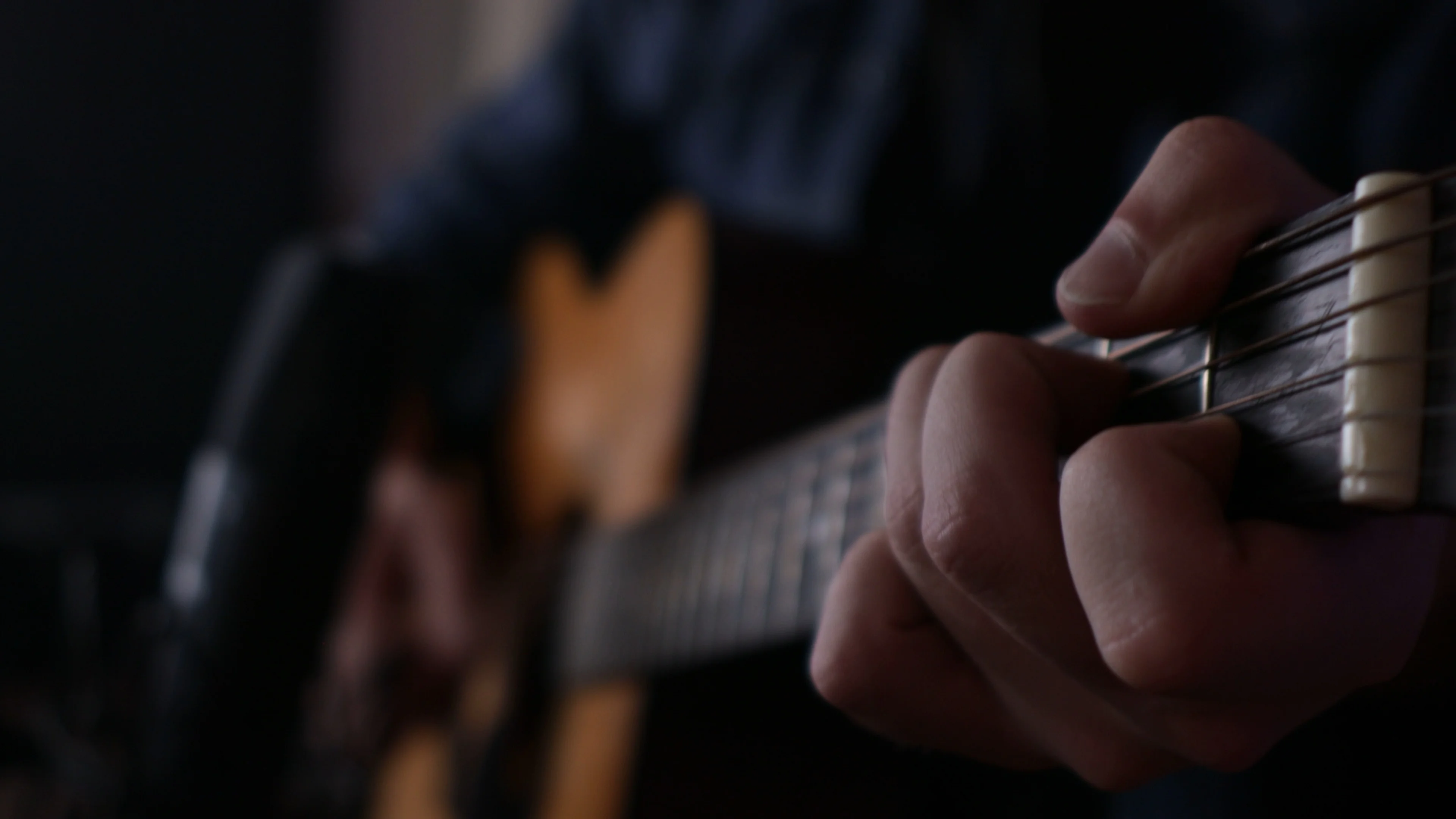 Close-up of Mattie's hand forming a chord shape illustrating why the progression works