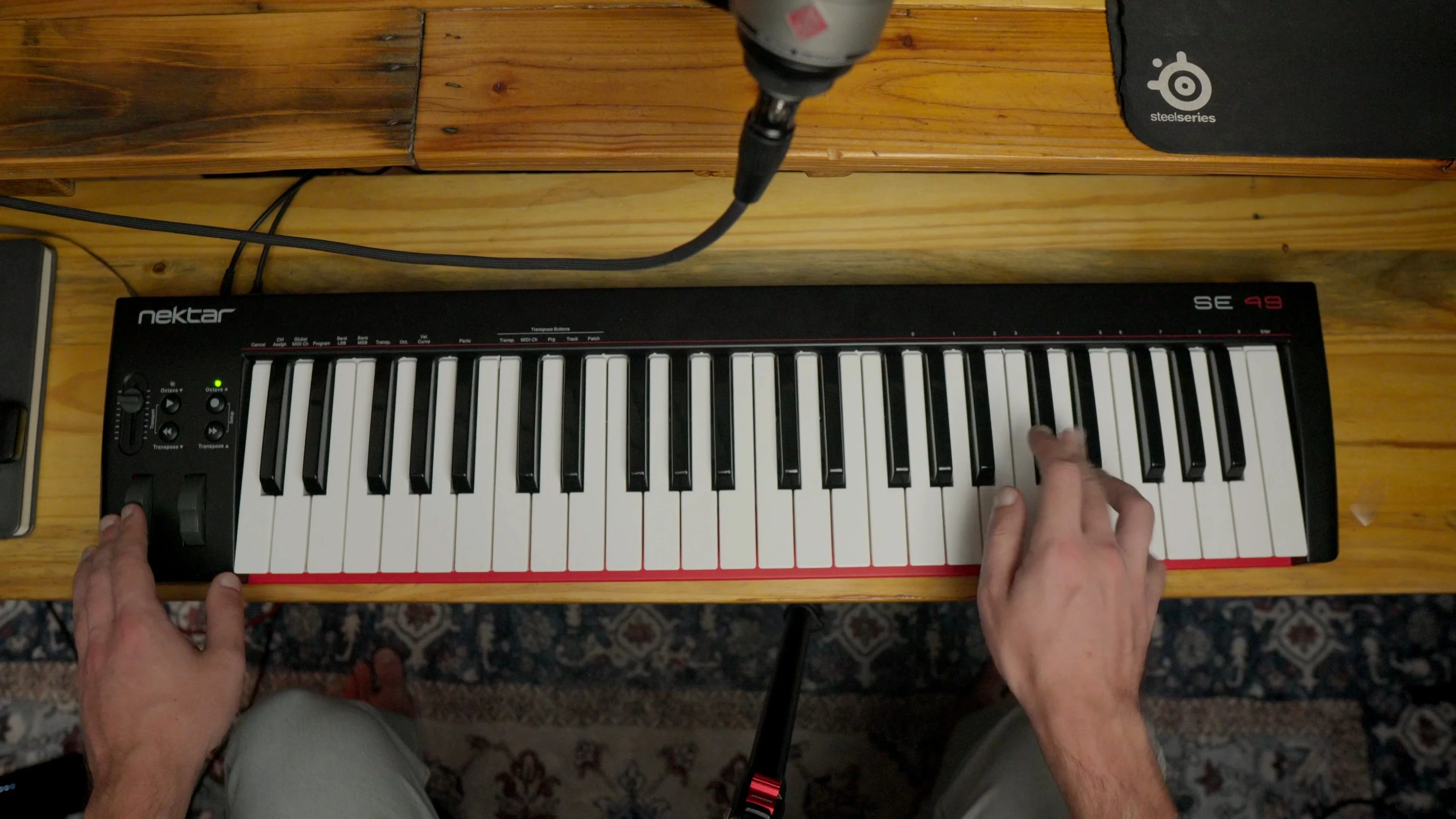 Close-up of hands playing MIDI keyboard controller, sharpening skills on a core music production tool