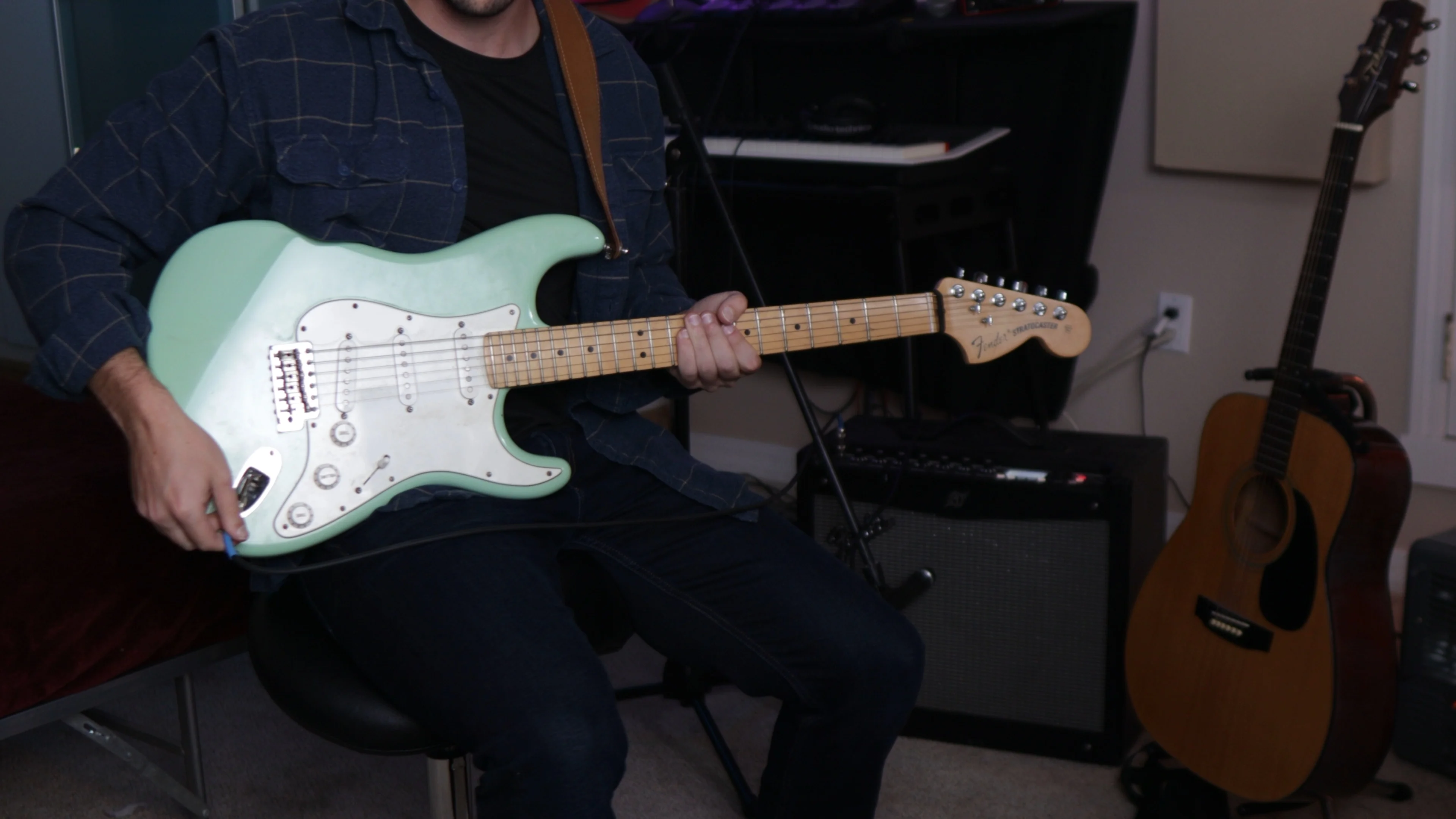 Musician recording live instrumentation over programmed beat in home studio session