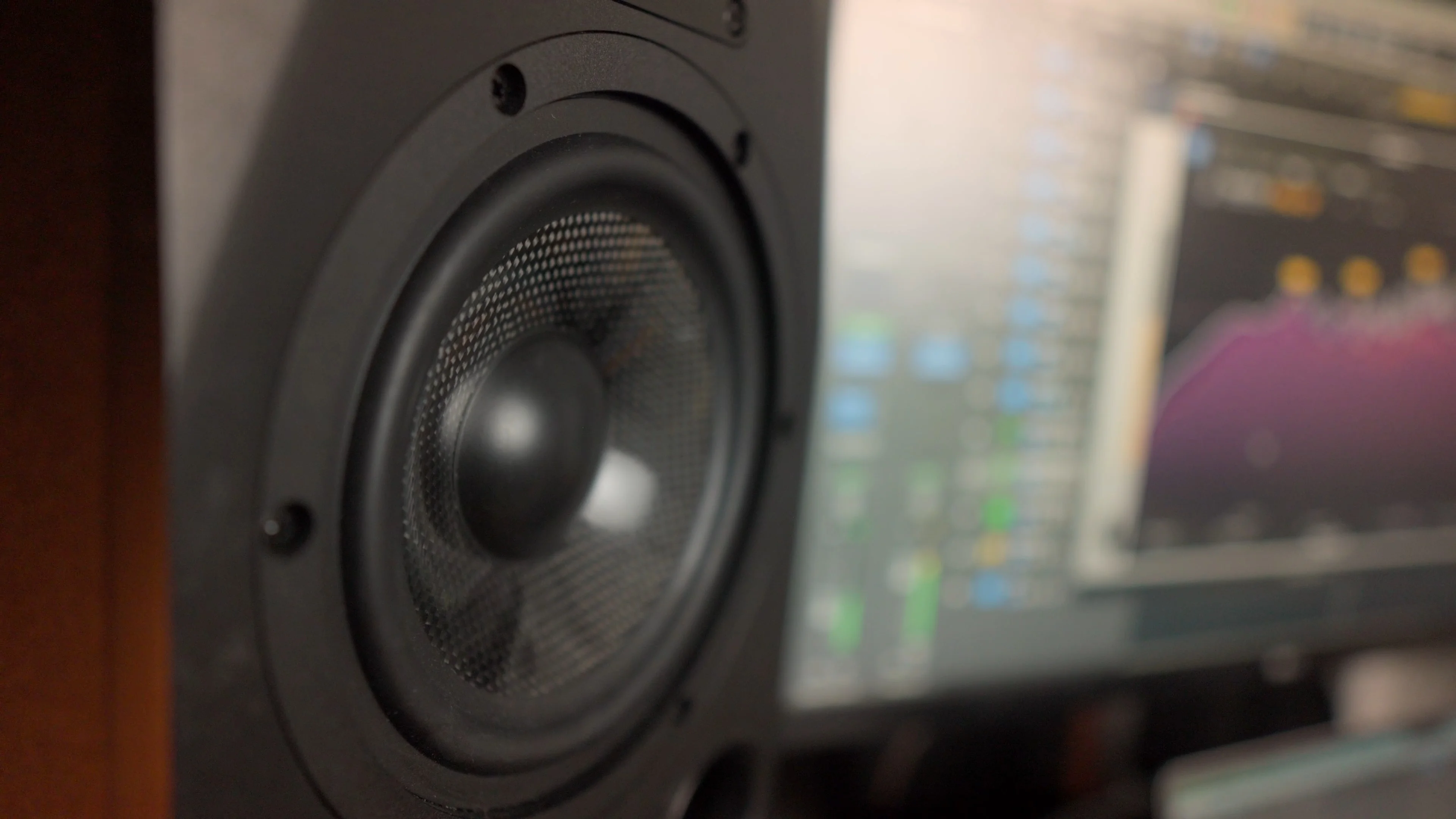 Studio monitor speaker with audio software on screen, visualizing the EQ curve analysis