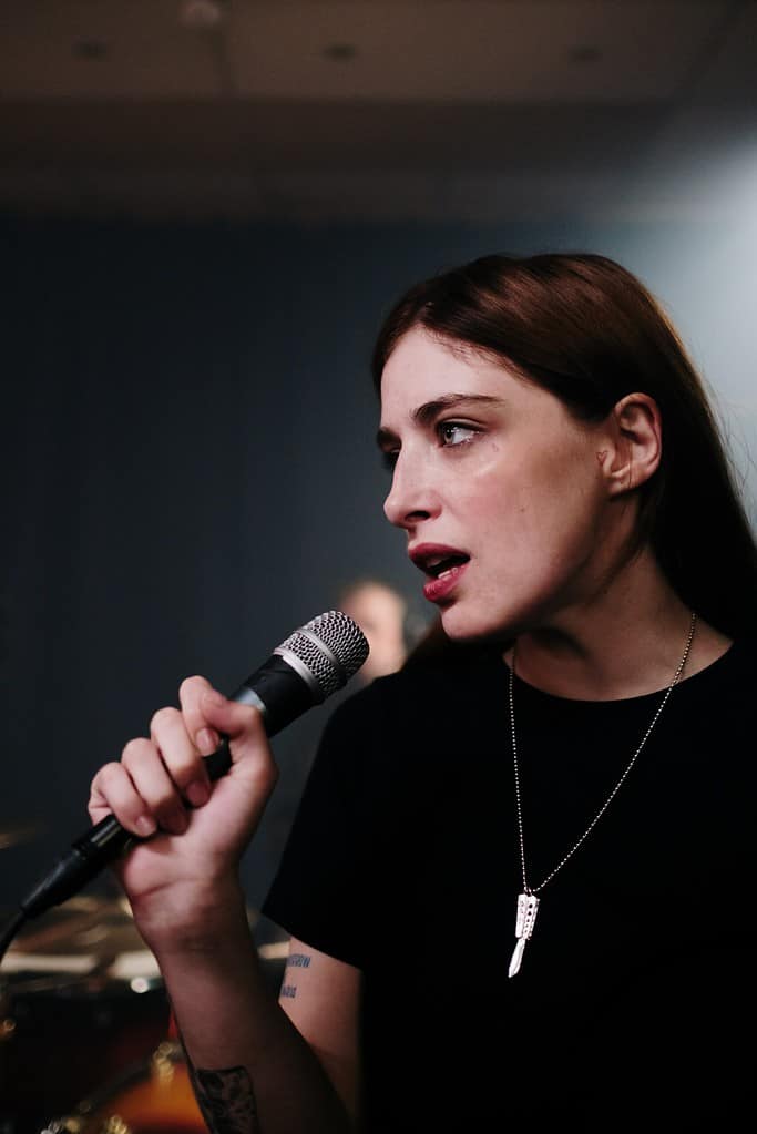 young adult singing into a microphone