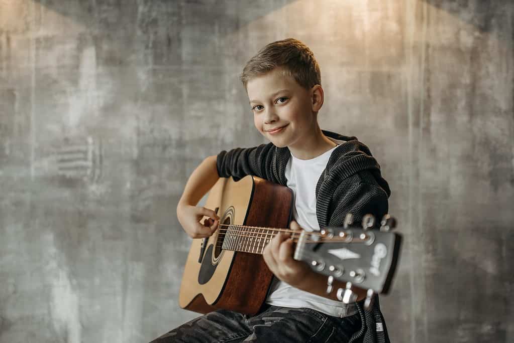Smiling Child Playing Acoustic Guitar