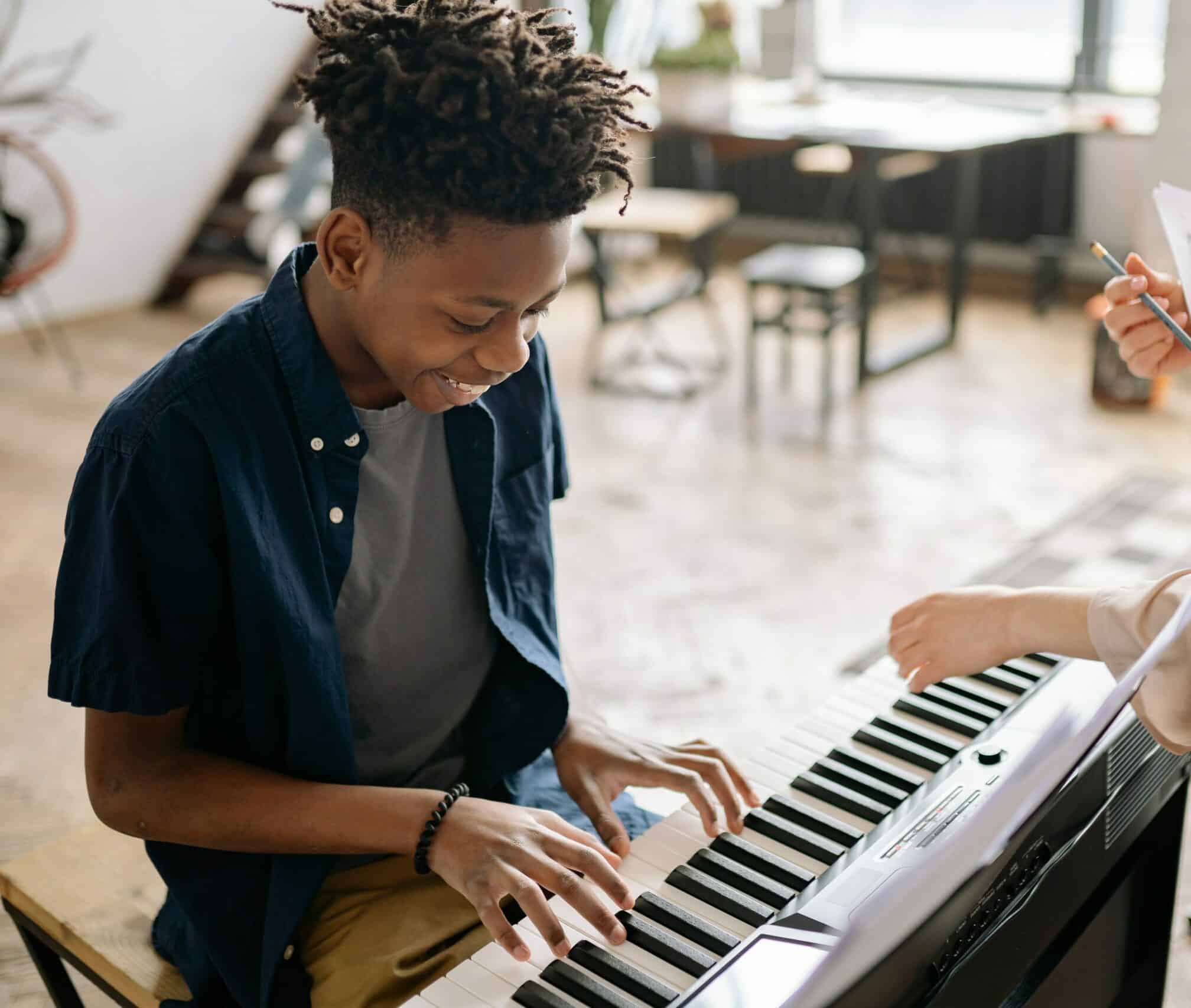 a young boy teenager playing piano and having fun